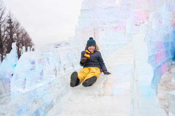 istock happy boy slides down an ice slide in winter outside 1501039228