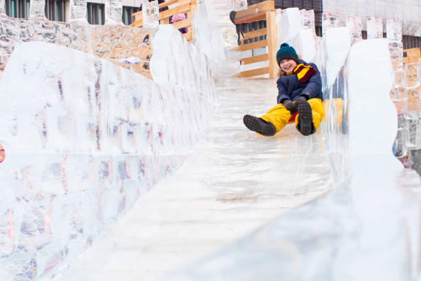 istock happy boy slides down an ice slide in winter outside 1501039355