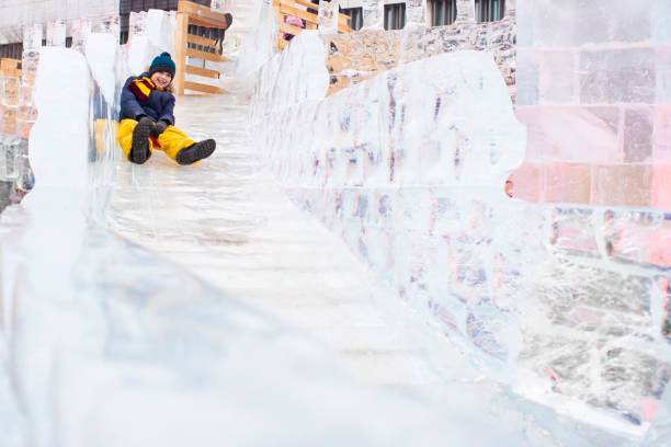 istock happy boy slides down an ice slide in winter outside 1501039444
