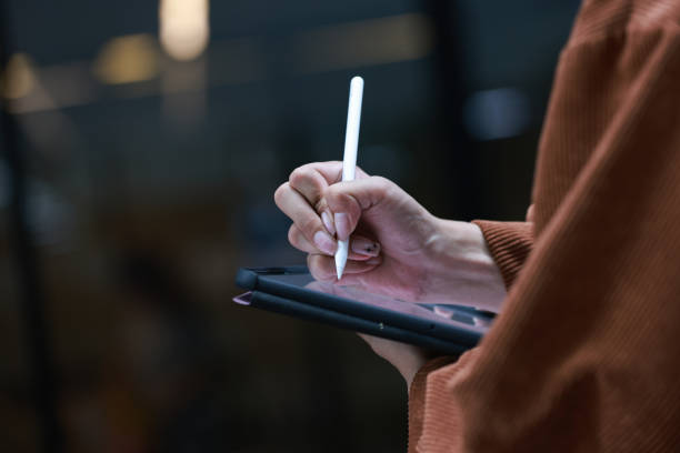 istock The thinking ideas strategy working concept on a tablet in UNIVERSITY, Close up Asian man hand holding smartphone and using smart pen technology for writing on tablet portable. digital student hand 1501041925