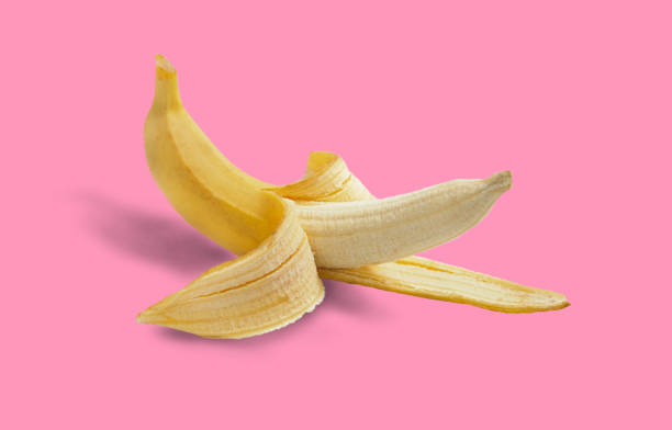 istock Half peeled ripe banana with peel on a pink background. 1501043326