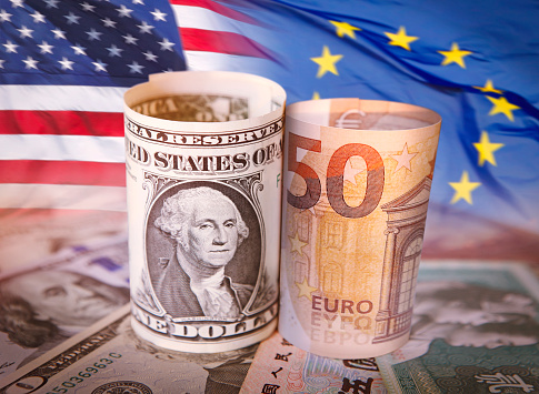 US dollar and Euro banknote with flags behind