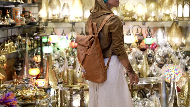 Woman shopping for arabic style traditional lamps in the souk