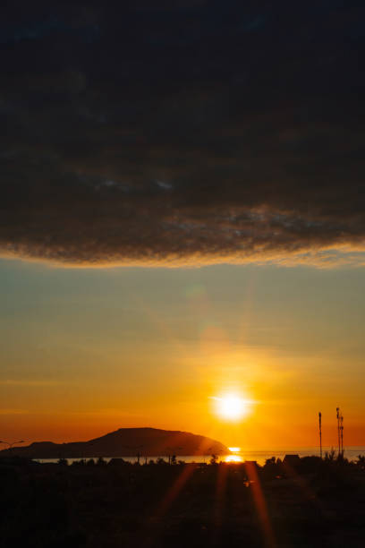 A sunset with a dark cloud in the sky