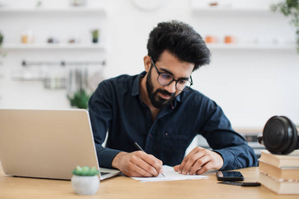 istock Remote employee making notes on paper in workplace at home 1501055172