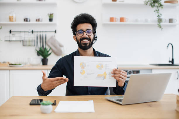 istock Male in headset posing with infographics in home workplace 1501055208