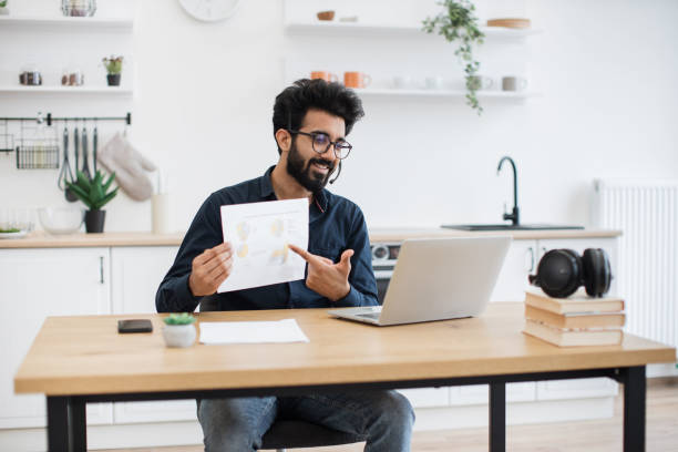 istock Analyst holding paper with charts at online briefing at home 1501055211