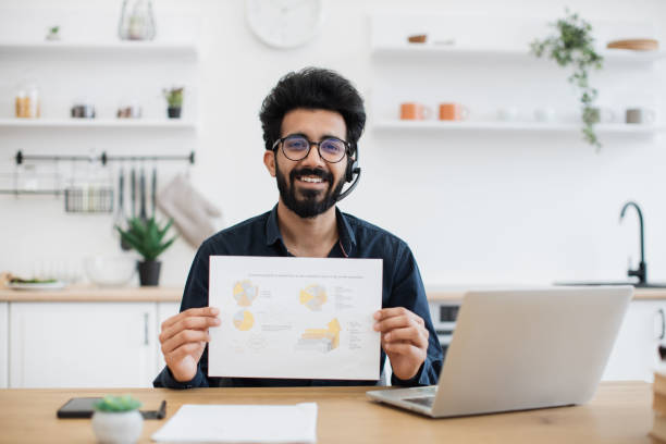 istock Male in headset posing with infographics in home workplace 1501055215