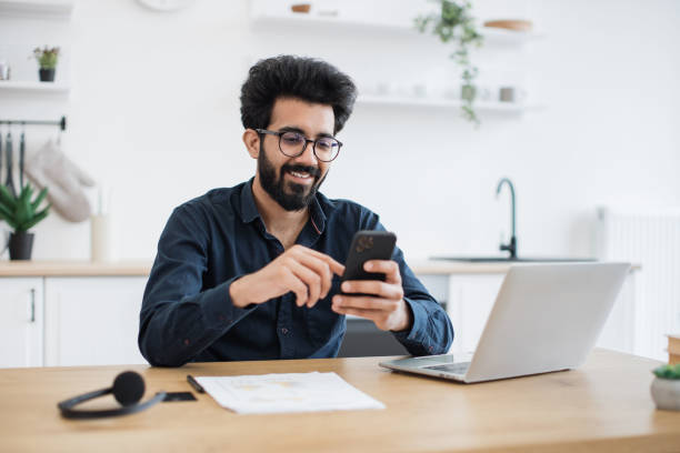 istock Male texting message on phone in kitchen during working hour 1501055237