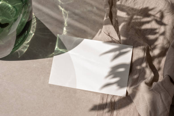 istock Blank paper card mock up on beige tabletop background with aesthetic sunlight shadows, minimalist business brand template, wedding invivation design, copy space 1501060335