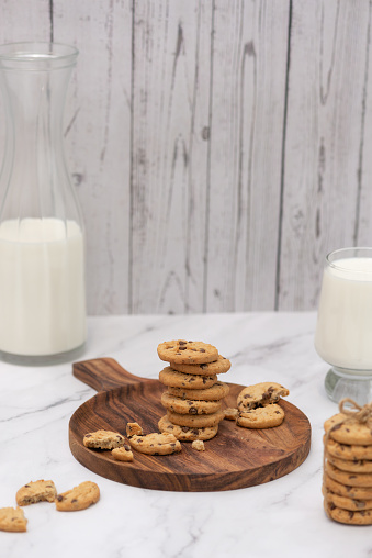 Home baked cookies and glass of milk on a kitchen table. Home cooked concept. Sill life food photography.