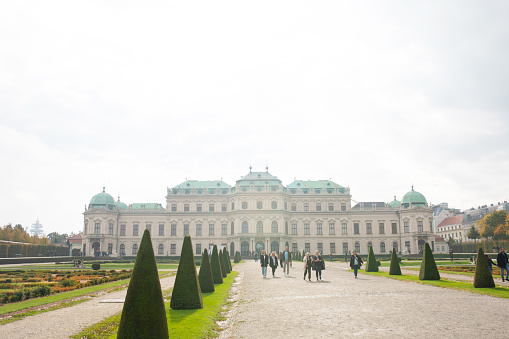 The classical symmetric gardens of the Belvedere palace in Vienna, Austria with its fountain and classic marble sculptures.