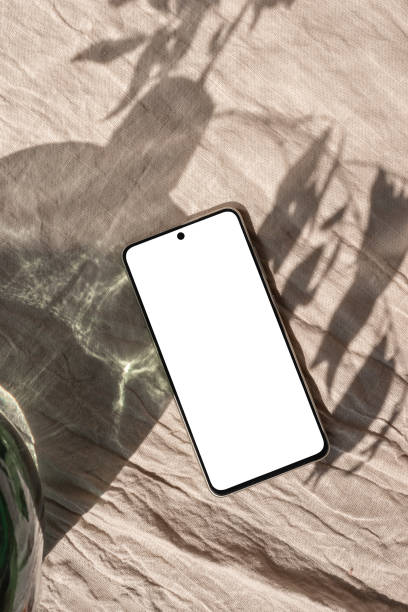 istock Mobile phone with blank screen mock up on neutral beige linen background with aesthetic floral sunlight shadow, minimalist business brand, social media blog template, copy space 1501060420