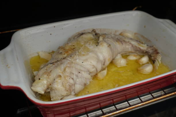 Monkfish stuffed with garlic cooked in the oven with lemon juice and olive oil  French cuisine Monkfish stuffed with garlic cooked in the oven with lemon juice and olive oil  French cuisine stargazer fish stock pictures, royalty-free photos & images