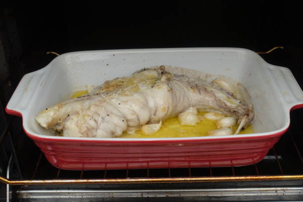 Monkfish stuffed with garlic cooked in the oven with lemon juice and olive oil  French cuisine Monkfish stuffed with garlic cooked in the oven with lemon juice and olive oil  French cuisine stargazer fish stock pictures, royalty-free photos & images