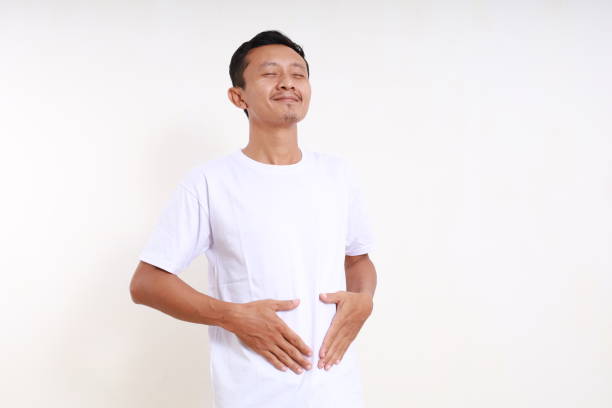 istock Asian funny man standing while holding his tummy. He feels full. Isolated on white background 1501064143
