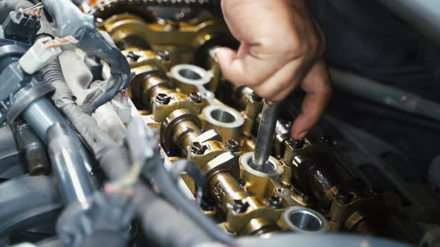 Auto mechanic working repairing engine mechanics garage. Car service fixing vehicle.