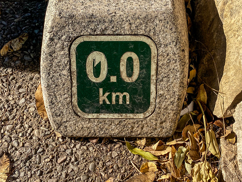 Kilometre zero point distance marker for the start of an outdoor running track in the Turia Garden in the city of Valencia, Spain