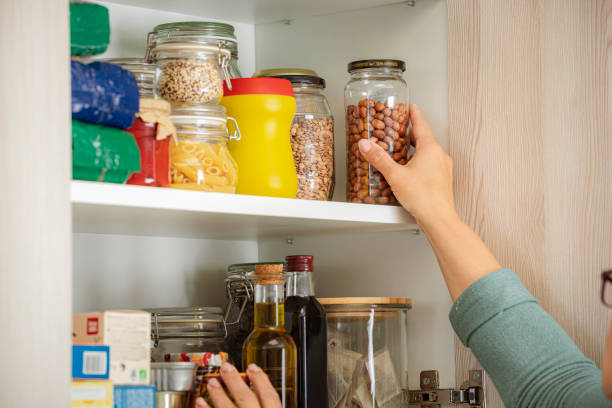 istock Female hand picking ingredient for cooking from kitchen cabinet 1501071434