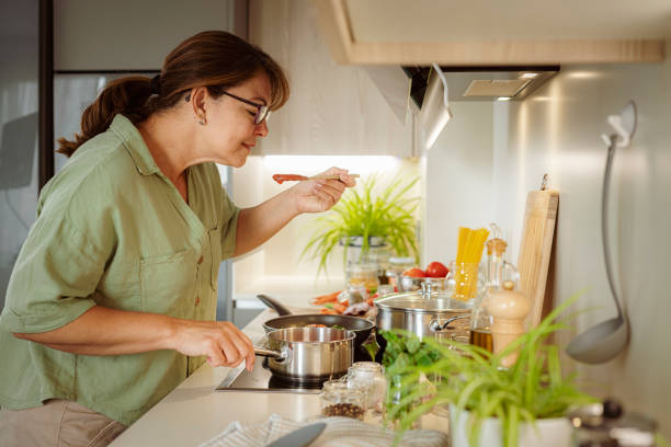 istock Woman cooking spaghetti and tasting tomato sauce 1501072374
