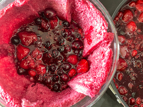 Stock photo of British homemade summer pudding recipe dessert with seasonal summer fruit and berries of strawberries, raspberries, blackberries, red currants, blackcurrants and blueberries, summer fruit pudding made with slices of white bread and juice syrup.