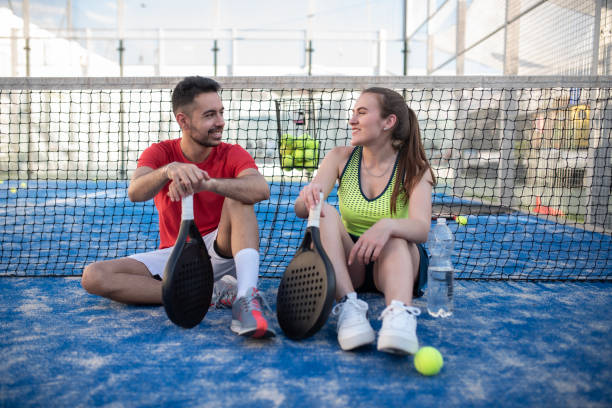 paddle-tennis-paarspieler, die eine pause machen - mixed age stock-fotos und bilder