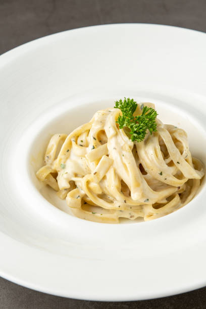 istock Freshly made fettucini alfredo on a white porcelain plate 1501077236