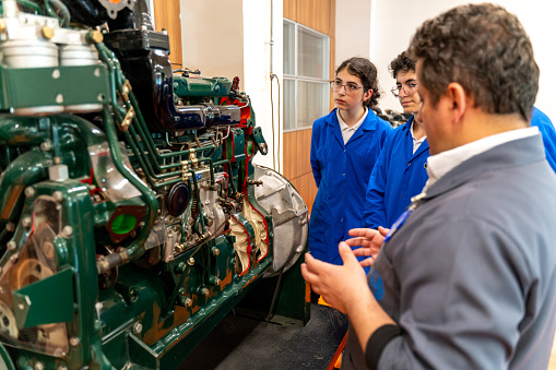 Group Of Students Studying For Auto Mechanic Apprenticeship At Vocational Education