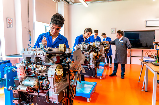 Group Of Students Studying For Auto Mechanic Apprenticeship At Vocational Education
