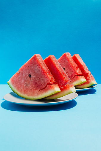 Front vertical view of slices of watermelon on blue background