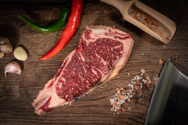 istock Raw beef steak with spices on a dark slate, stone or concrete background. Top view with copy space. 1501090877