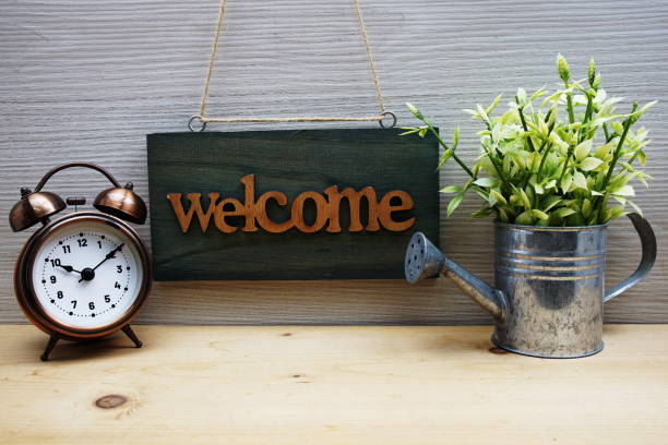 istock Welcome Sign with alarm clock on wooden background 1501096312