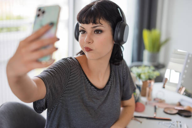istock Girl wearing headophones and making a face when taking a selfie 1501096381