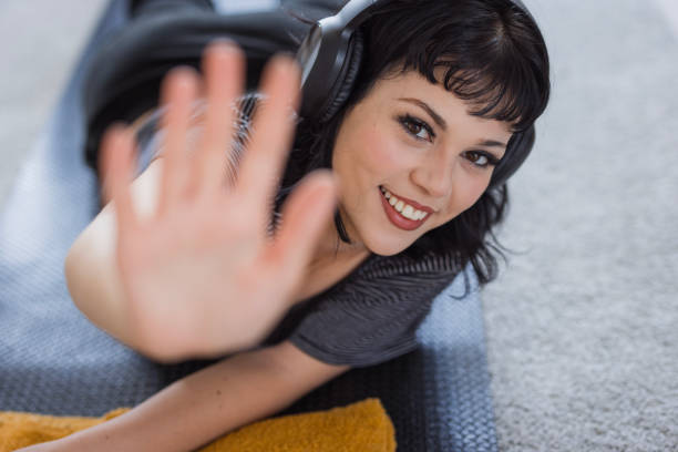 A happy girl with headphones stop-gesturing when smiling