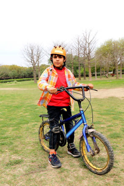 podstawowa jazda / zabawa dzieci na rowerze w parku. - clothing india delhi tired zdjęcia i obrazy z banku zdjęć