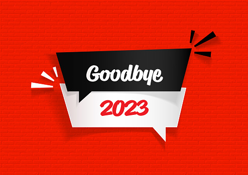 Goodbye 2023 written black and white speech bubbles on red brick background. Horizontal composition.