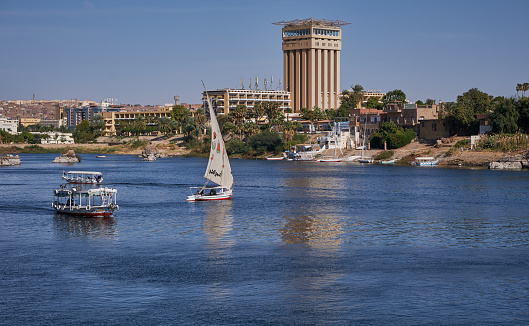 Nile river in Aswan, Egypt afternoon shot showing feluccas and boats in the river with elephantine Island (UNESCO World Heritage site)
