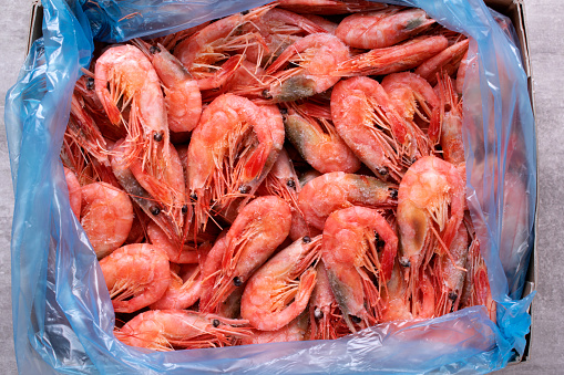 Frozen boiled shrimps in a box. Seafood product. Top view