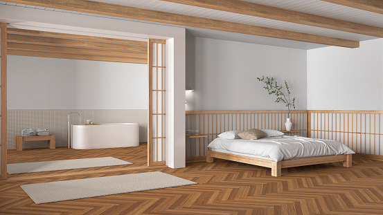 Minimal japandi bedroom and bathroom in wooden and white tones. Double bed with pillows, freestanding bathtub and herringbone parquet floor. Modern interior design