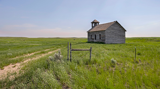 Abandoned Cottonwood Lutheran Church and a barbed wire fence near the town of Havre, Montana, USA