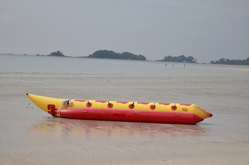 Yellow and red banana boats on the beach in holiday season