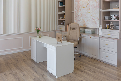 a close view of the home office in a modern cozy soft interior in warm delicate pastel pink and beige colors