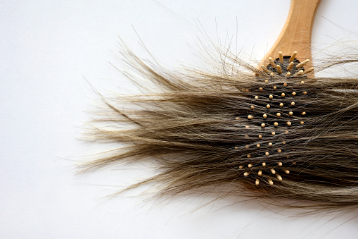 Hair and comb on white background.