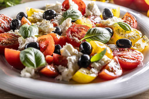 Vegetable food with mozzarella cheese named Caprese salad.