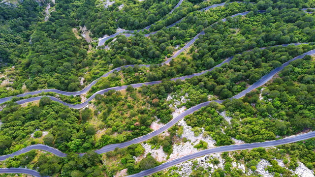 Winding road - Lovcensky serpentine with dangerous turns that leads to the top of the Montenegrin mountains covered with vegetation