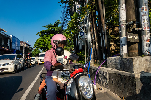 Ubud, Bali, Indonesia May 24, 2023 A person on a scooter on a busy street.