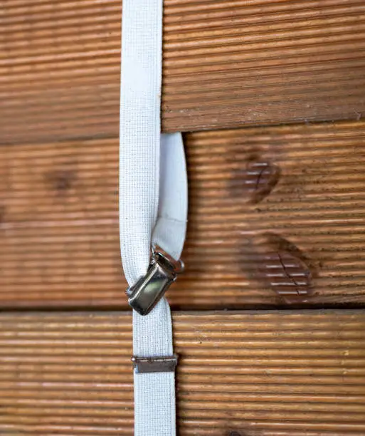 a white suspender on a wooden wall in selective focus