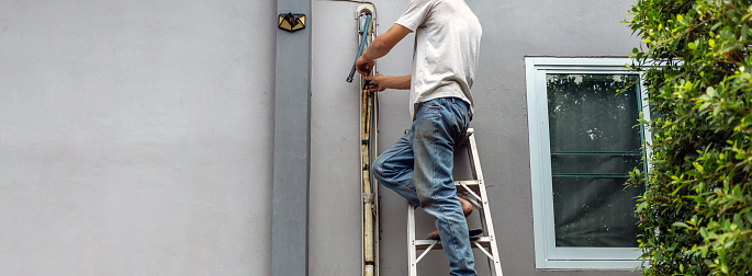 technician repairing and Dismantling the air duct outdoor air conditioning system