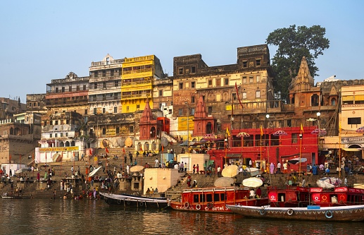 Varanasi, India, November 23, 2015: View of the Ahilyabai Ghat on the Ganges River in Varanasi illuminated by rising sun in the early morning.
