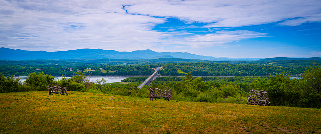 Panoramic Hudson Valley landscape with hilly meadow, the river, Rip Van Winkle Bridge, and horizon in upstate New York